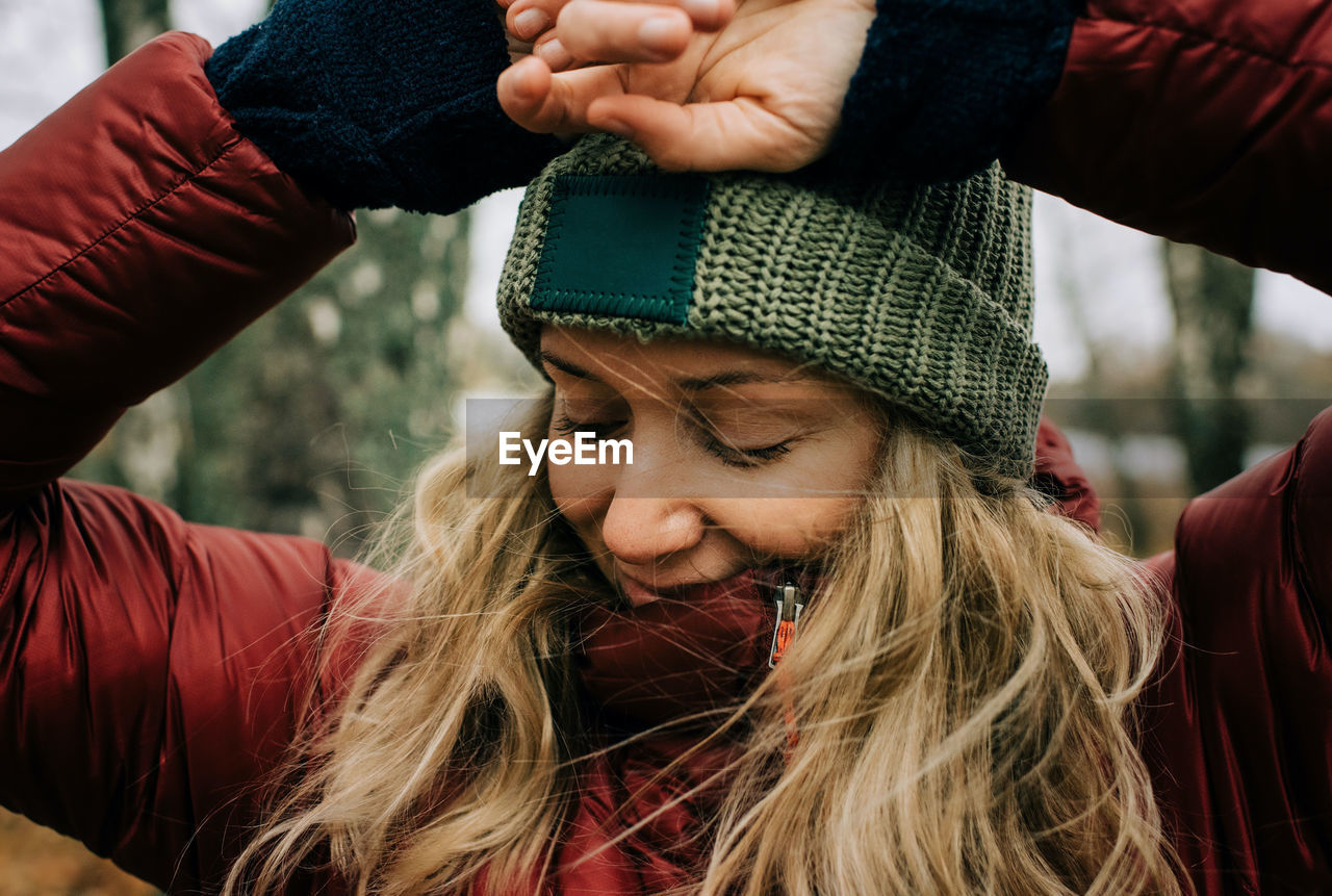 Portrait of a woman in the forest with the wind blowing her hair happy