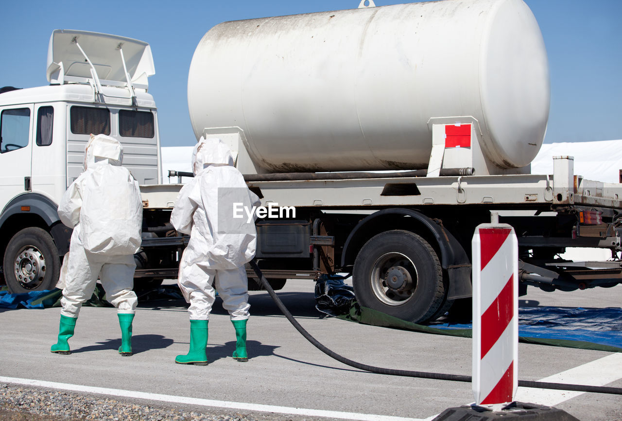 Rear view of workers walking towards vehicle