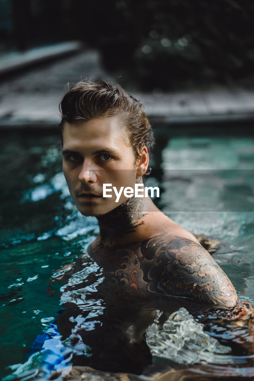 PORTRAIT OF YOUNG MAN SWIMMING POOL