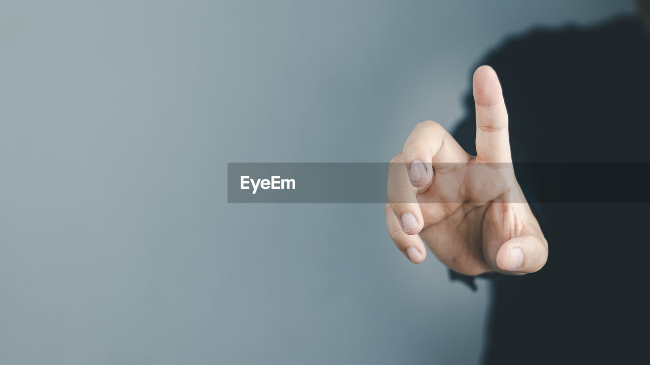 hand, finger, gesturing, sign language, studio shot, copy space, close-up, one person, indoors, hand sign, adult, arm, communication, showing, gray, men, gray background, pointing, success, thumbs up, business, emotion