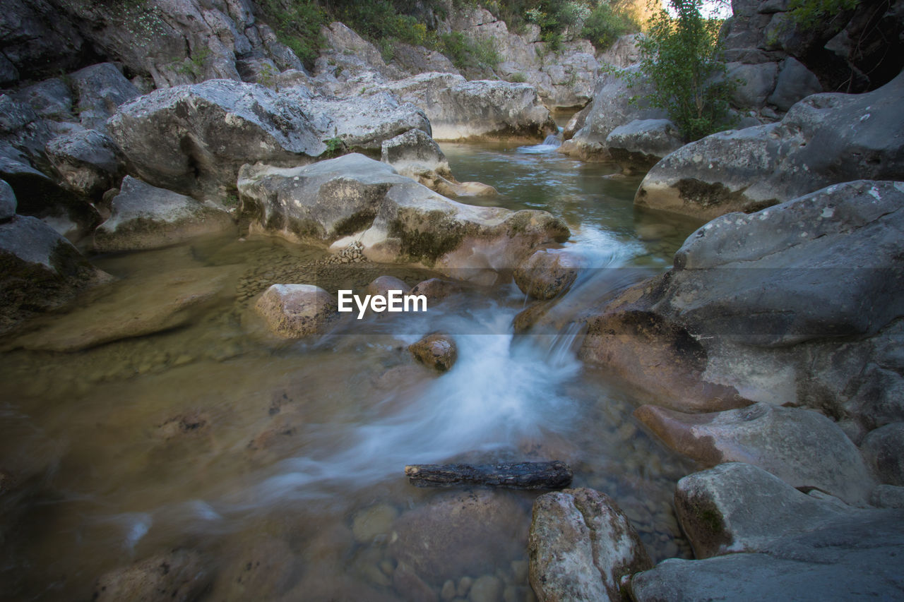 water, rock, beauty in nature, river, stream, rapid, nature, scenics - nature, wilderness, body of water, land, environment, creek, no people, tree, landscape, water feature, flowing water, plant, non-urban scene, motion, stream bed, forest, watercourse, outdoors, tranquility, day, valley, flowing, wet, wadi, long exposure, rock formation, travel destinations, travel