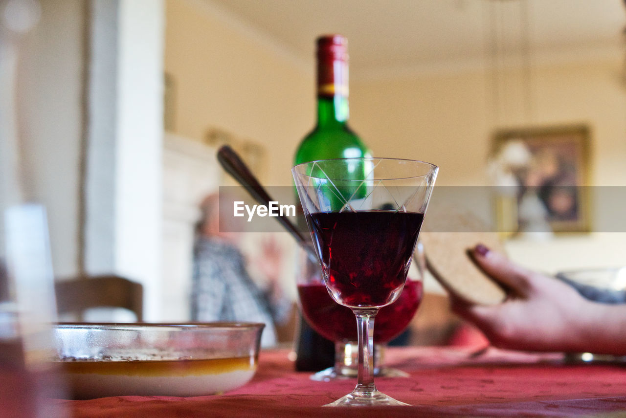 Glass of wine glasses and creme brulee on table