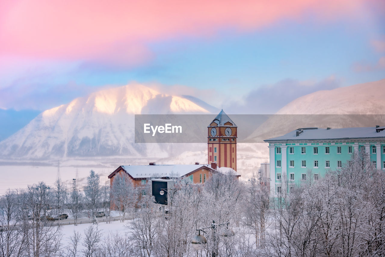 View of downtown kirovsk, murmansk, russia and the snow covered khibiny mountains in the arctic dawn 