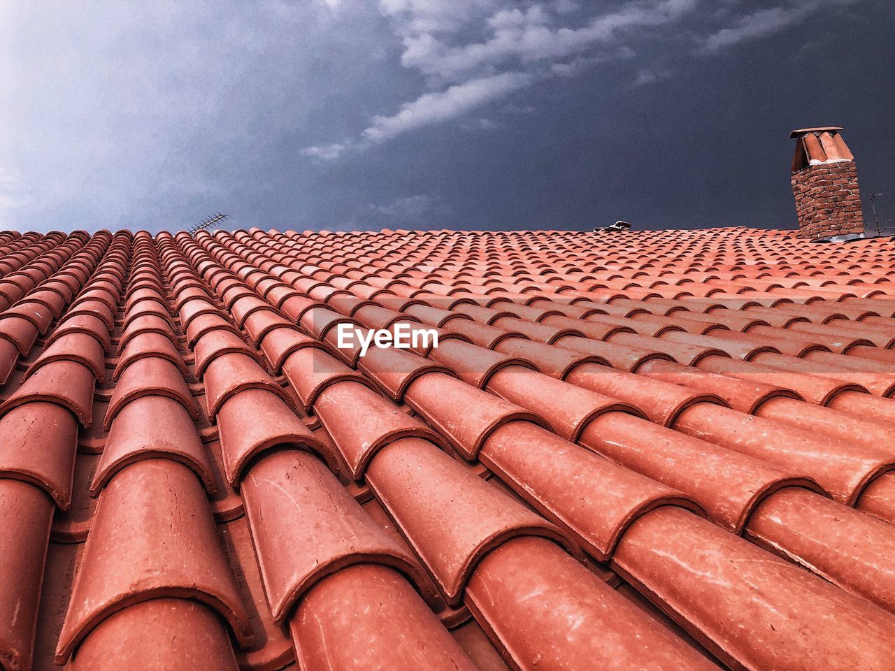 LOW ANGLE VIEW OF ROOF TILES AGAINST BUILDING