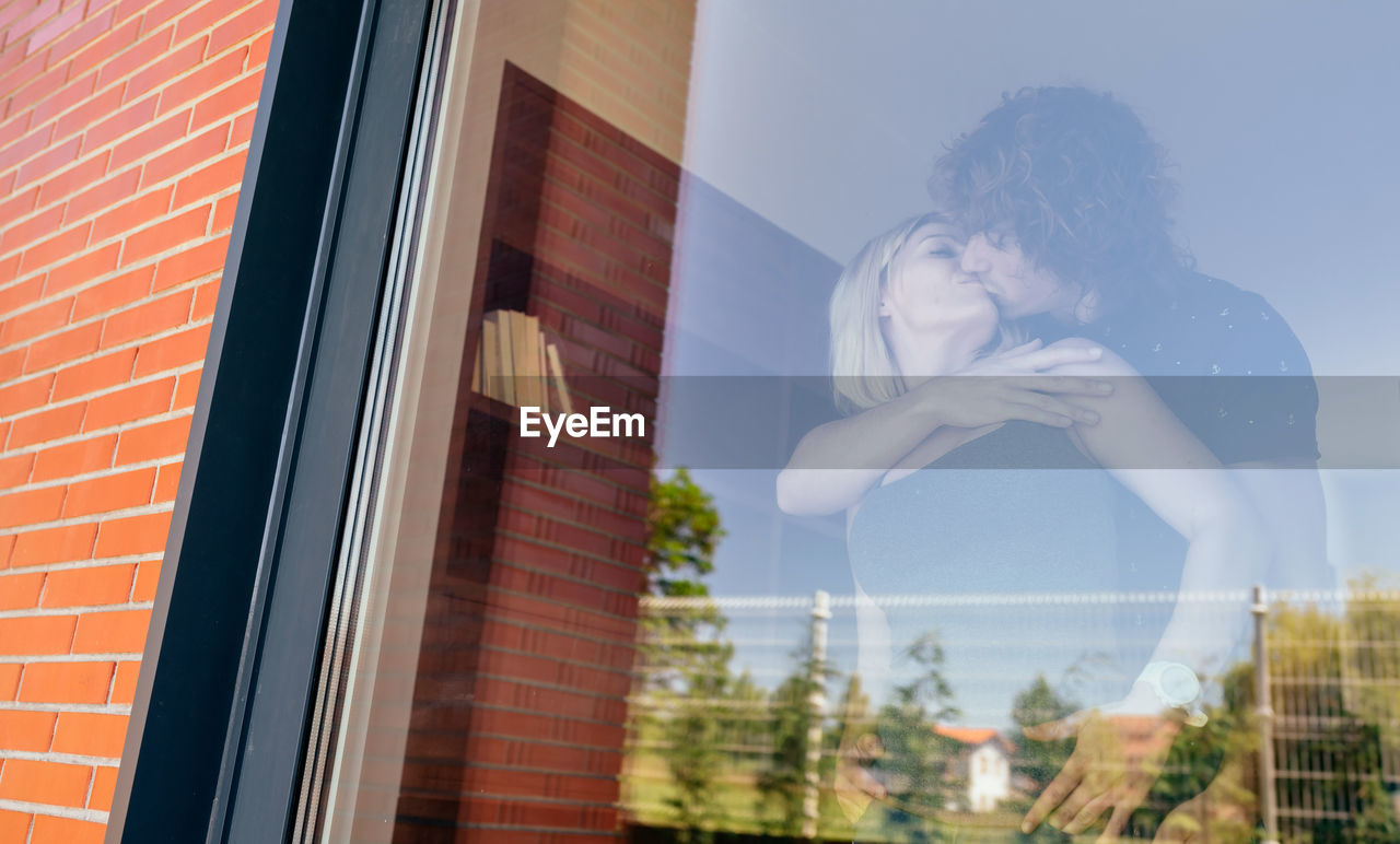Couple kissing seen through window