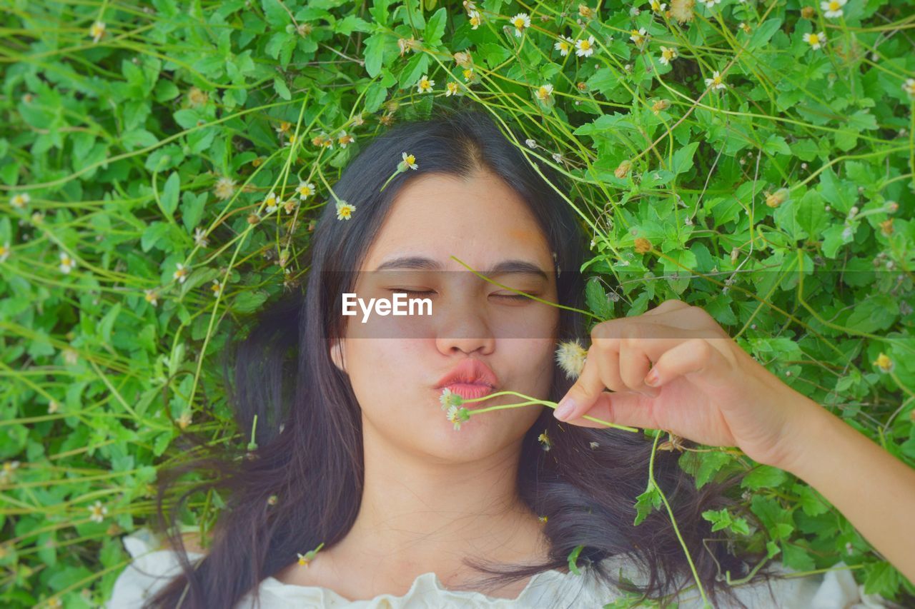 Portrait of young woman holding food outdoors