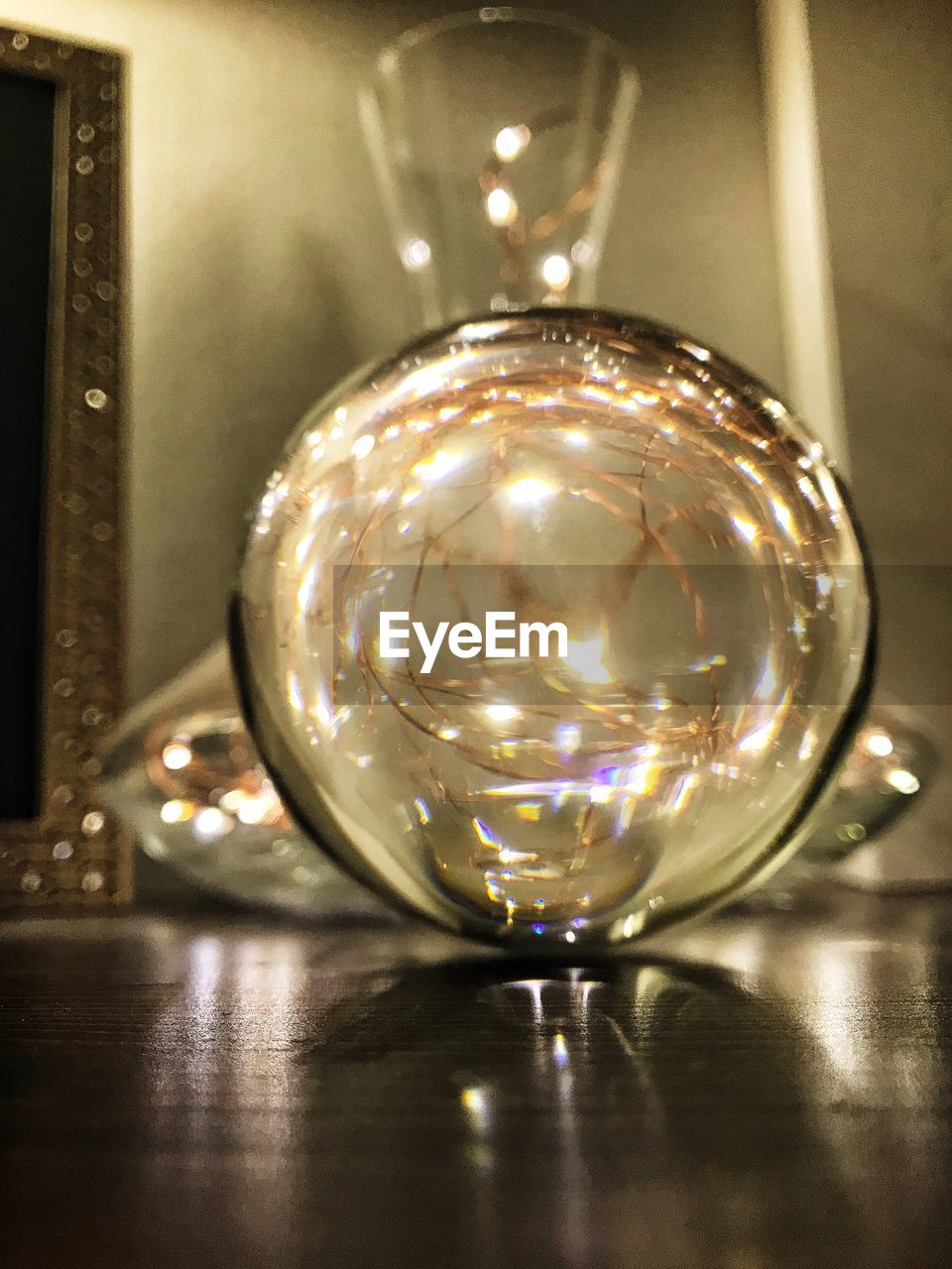 CLOSE-UP OF CRYSTAL BALL ON ILLUMINATED GLASS