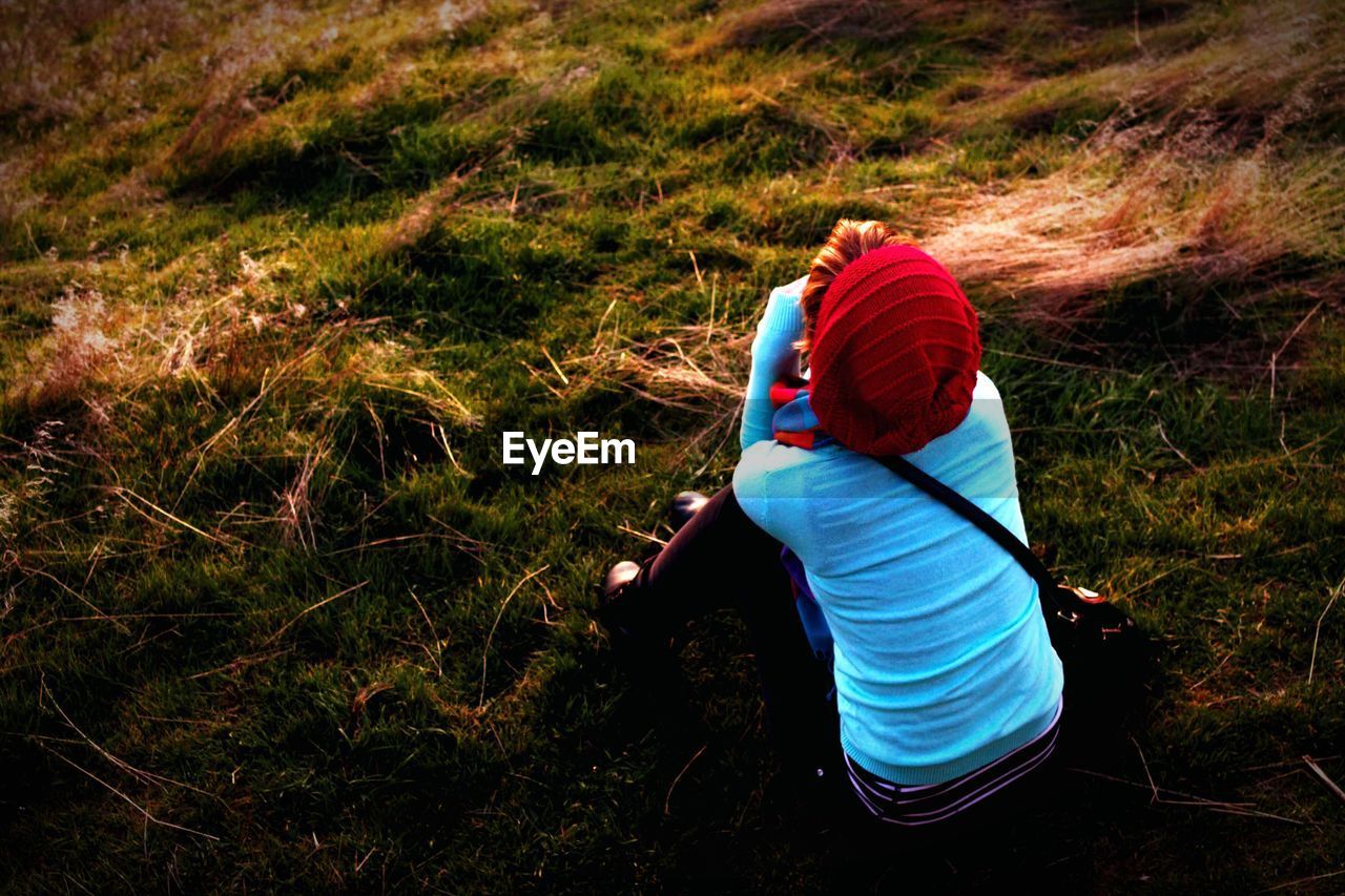 Girl sitting on grass watching the sunset