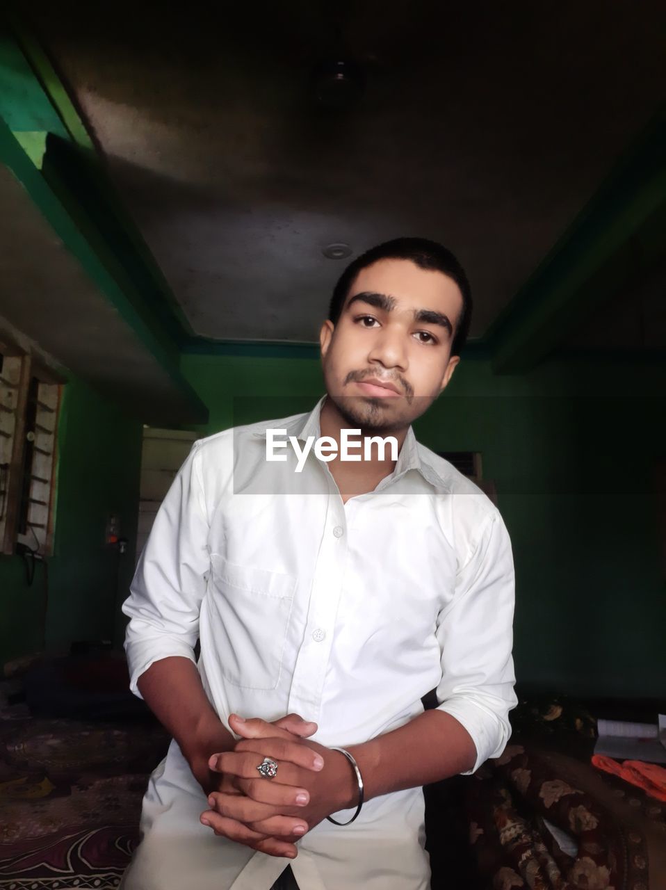 Portrait of young man standing against wall