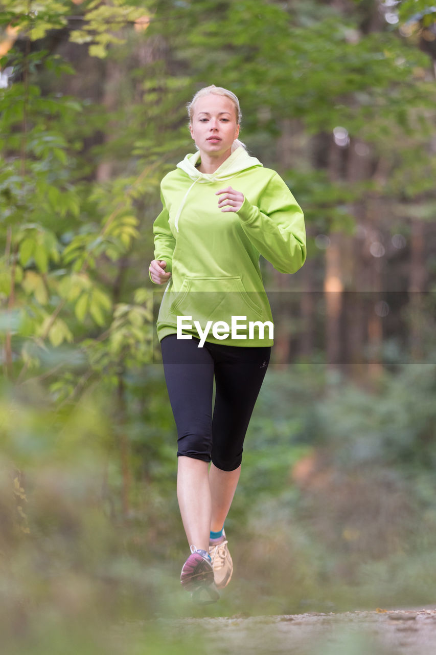 Full length of a woman running on plant