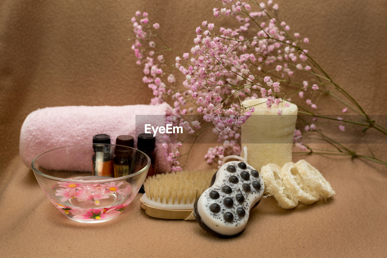 Handmade massage soap scrub with black clay in brown background with a towel and a massage brush.