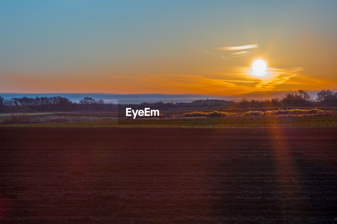 Scenic view of field against sky during sunset