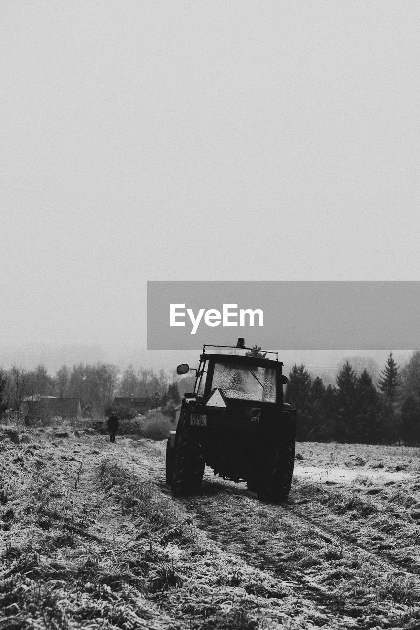 transportation, mode of transportation, nature, black and white, vehicle, land vehicle, land, sky, day, snow, field, landscape, environment, clear sky, monochrome photography, no people, monochrome, rural scene, tree, transport, rural area, copy space, agricultural machinery, outdoors, agricultural equipment, plant, tractor