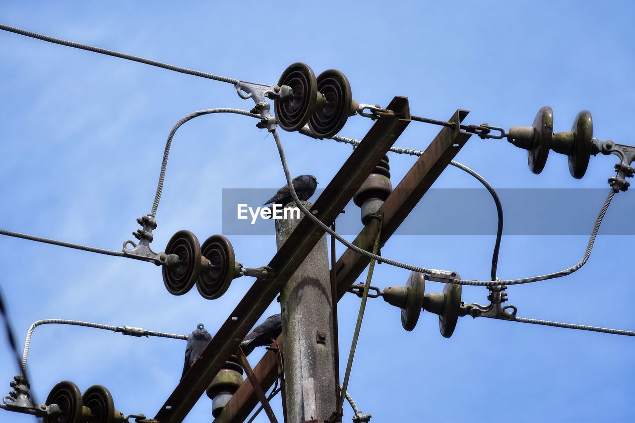 electricity, blue, sky, cable, no people, low angle view, street light, technology, nature, mast, day, communication, sign, lighting, outdoors, overhead power line, power line, electrical supply, fence