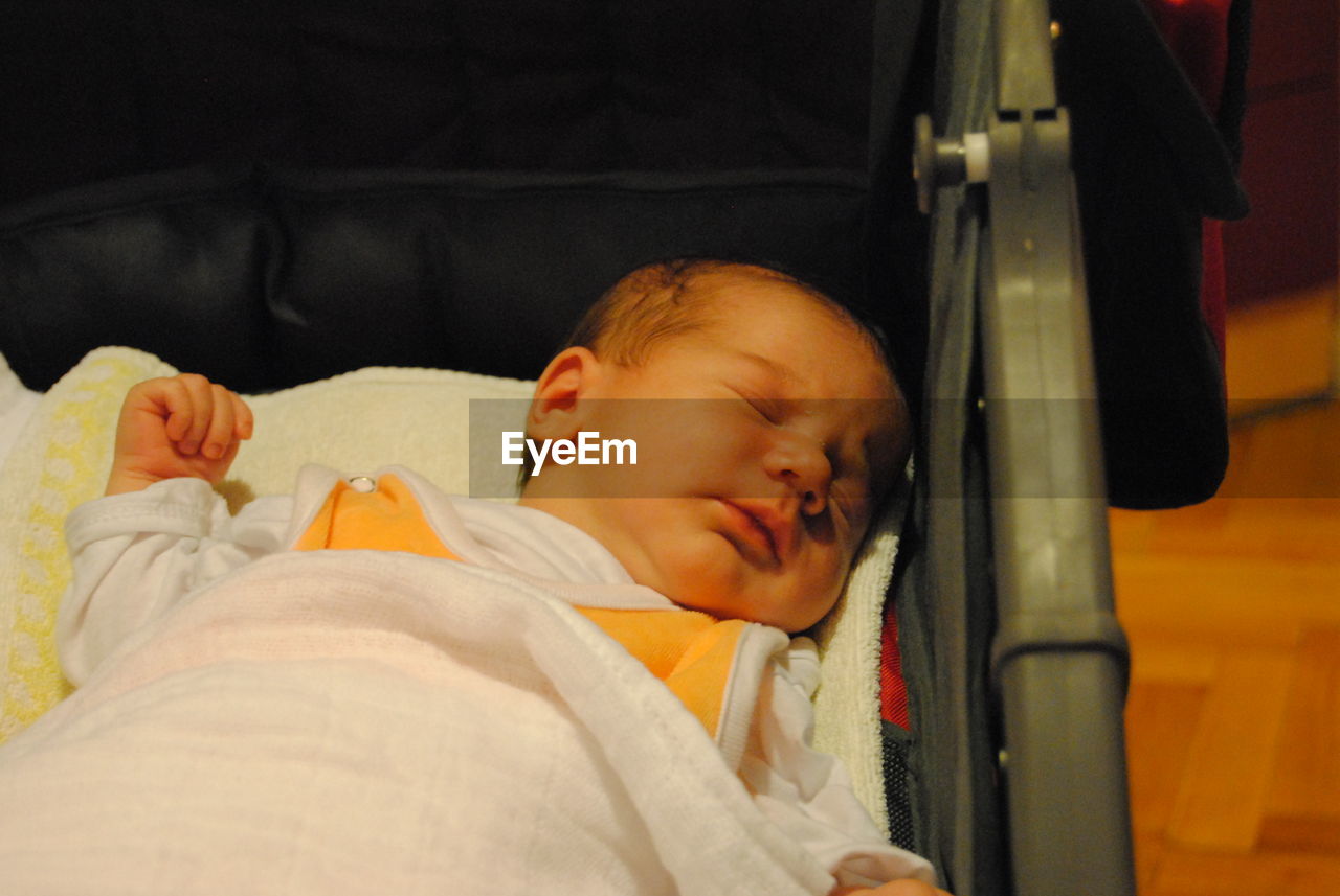 Baby boy sleeping in stroller at home