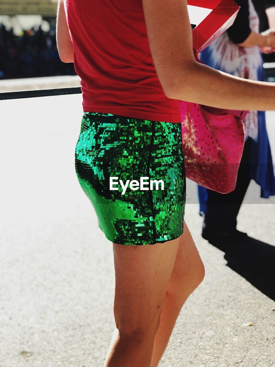 Midsection of woman wearing green sequin skirt while standing on street