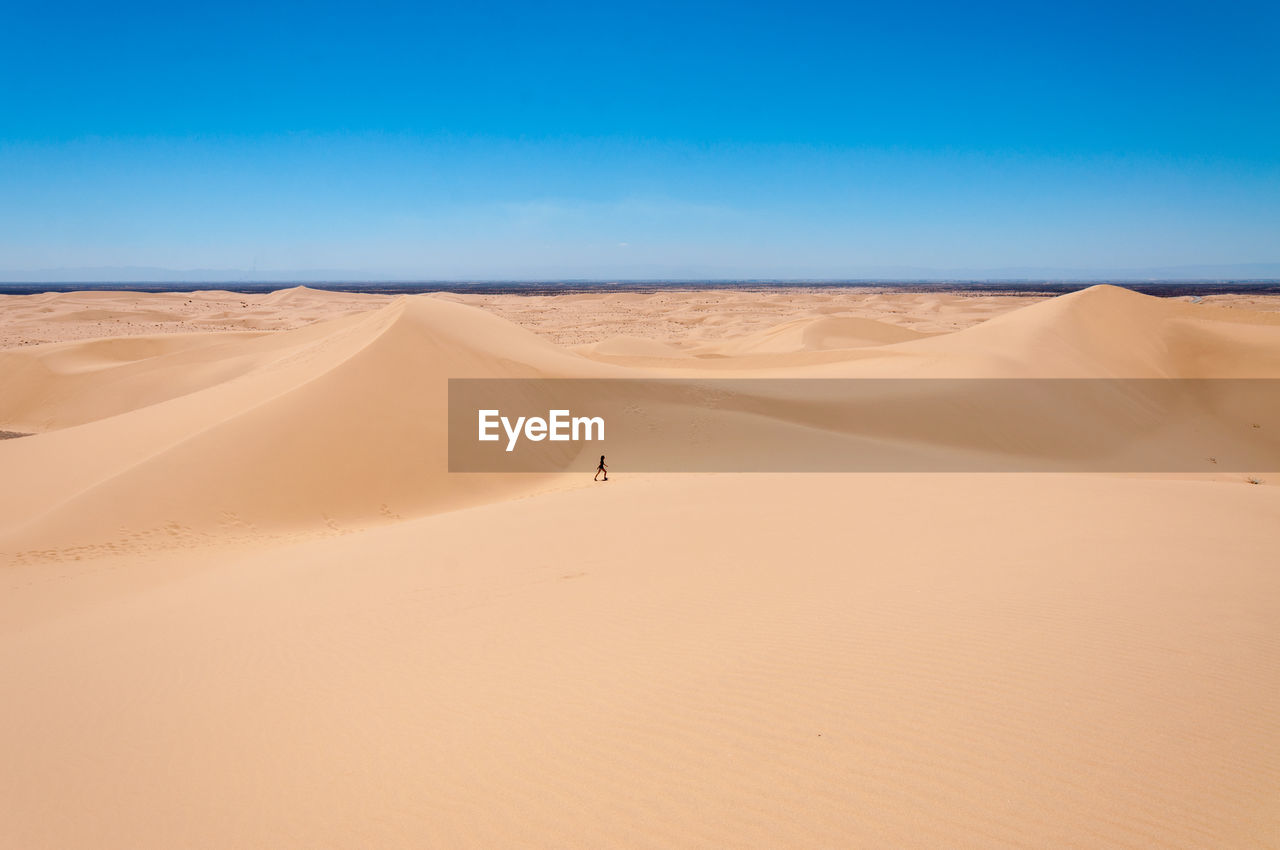 Teenage girl on desert against sky