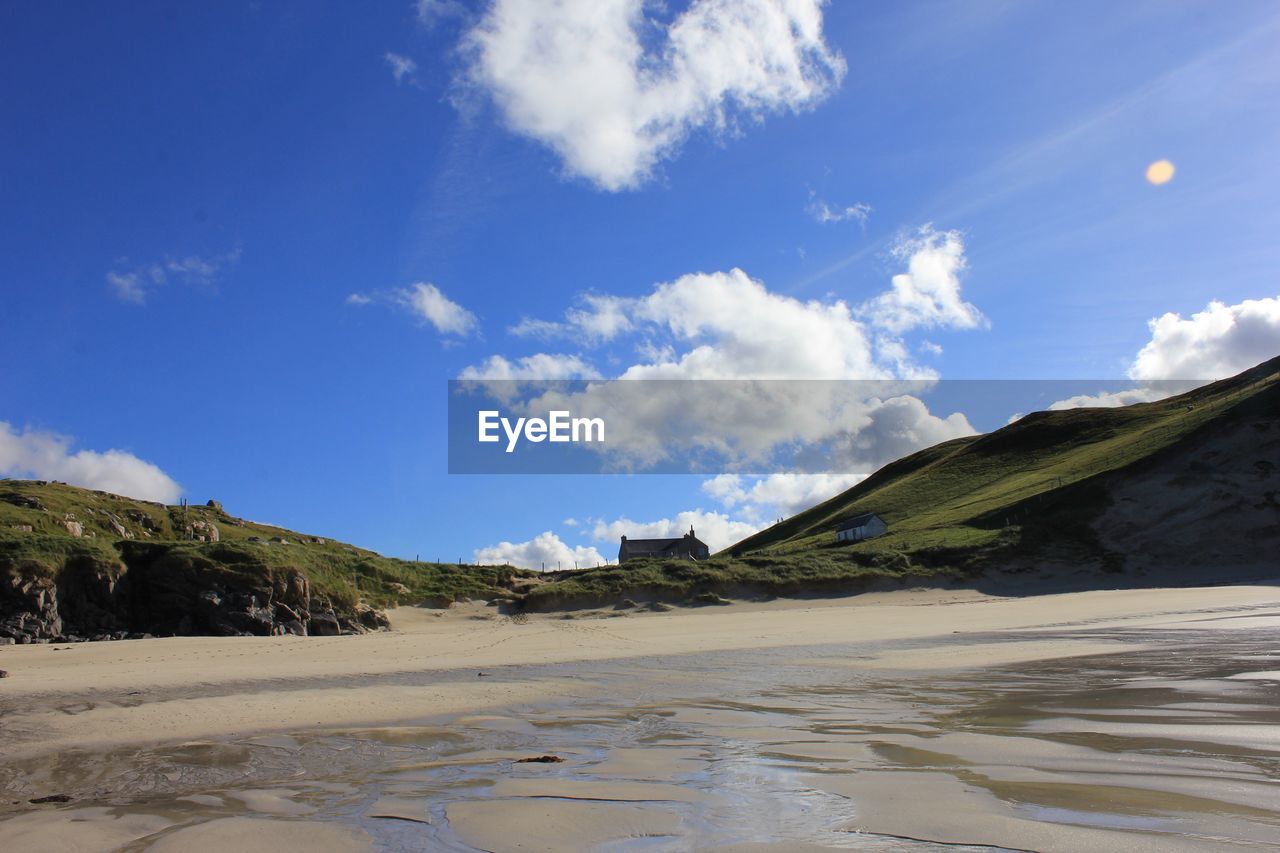 View of calm beach against blue sky