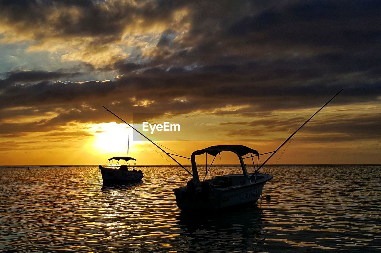 FISHING BOAT IN SEA DURING SUNSET