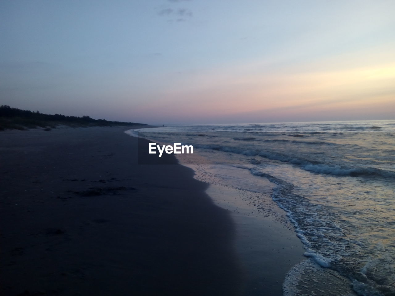 SCENIC VIEW OF BEACH DURING SUNSET