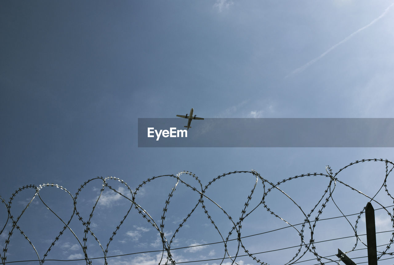 Low angle view of airplane flying against sky