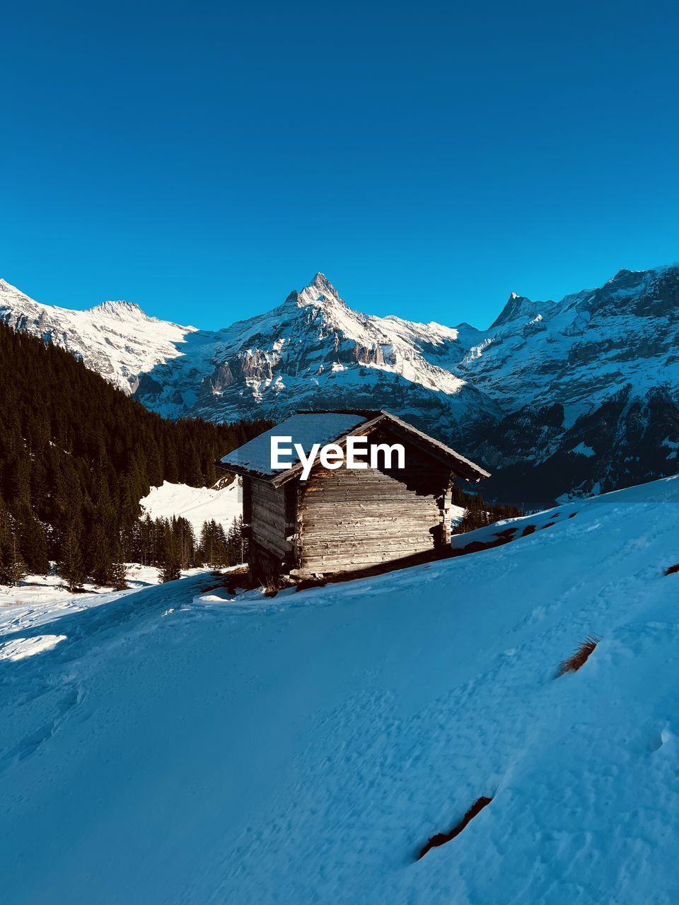 Scenic view of snowcapped mountains against clear blue sky