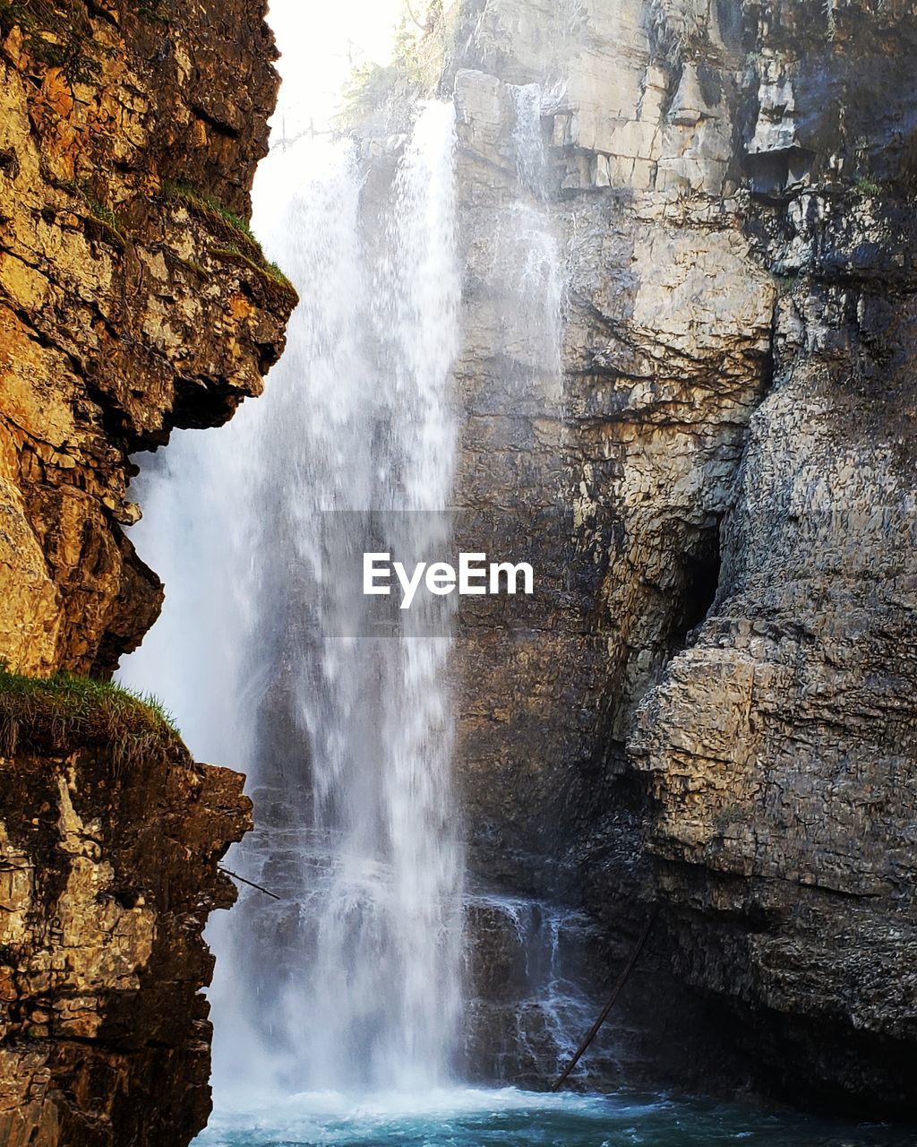 SCENIC VIEW OF WATERFALL AGAINST ROCKS