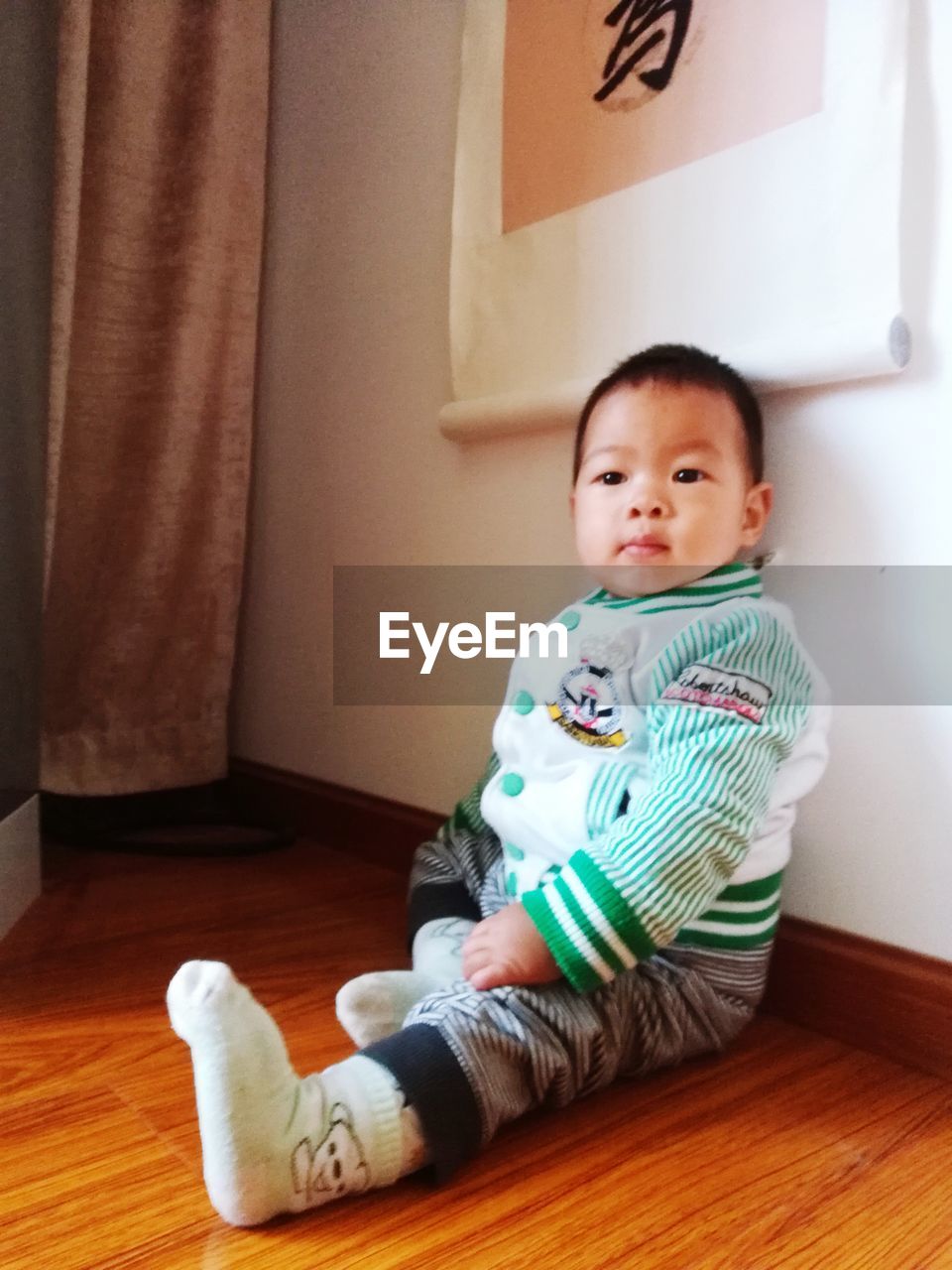 PORTRAIT OF CUTE BOY SITTING AT HOME