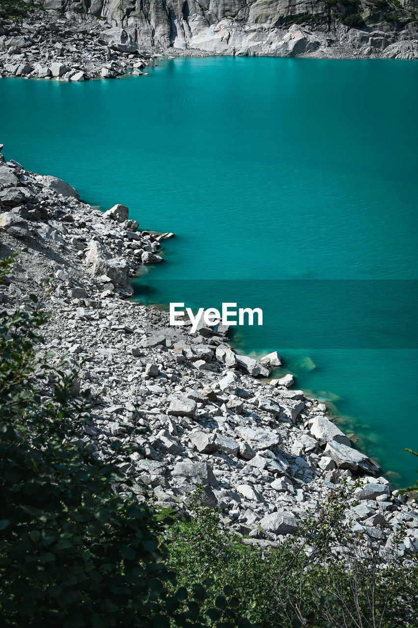 High angle view of rocks on mountain lake beach