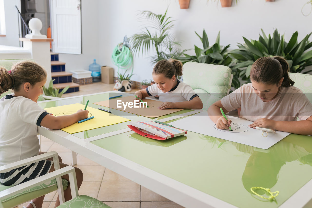 Girls making sketches at home