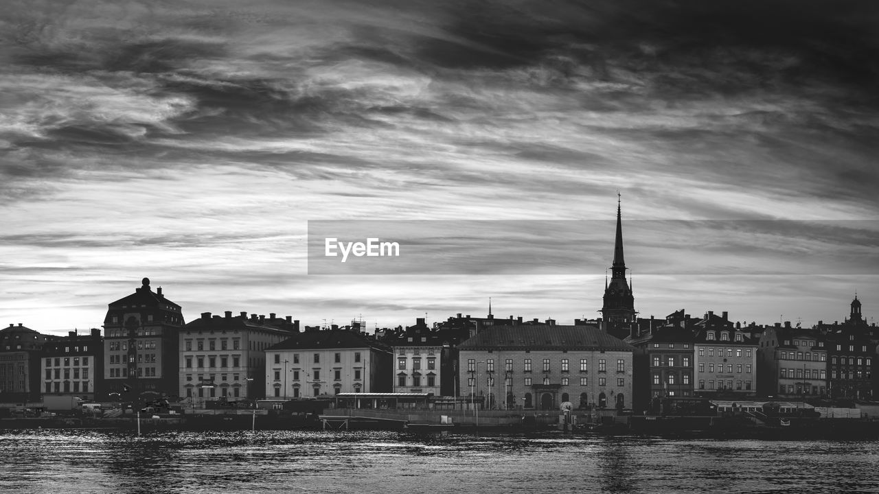 Buildings in city against cloudy sky