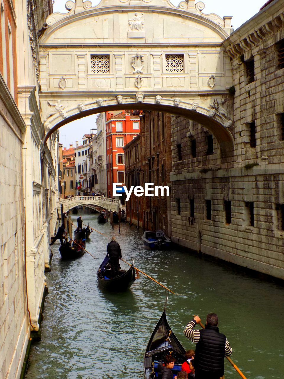 People in gondolas in grand canal amidst buildings