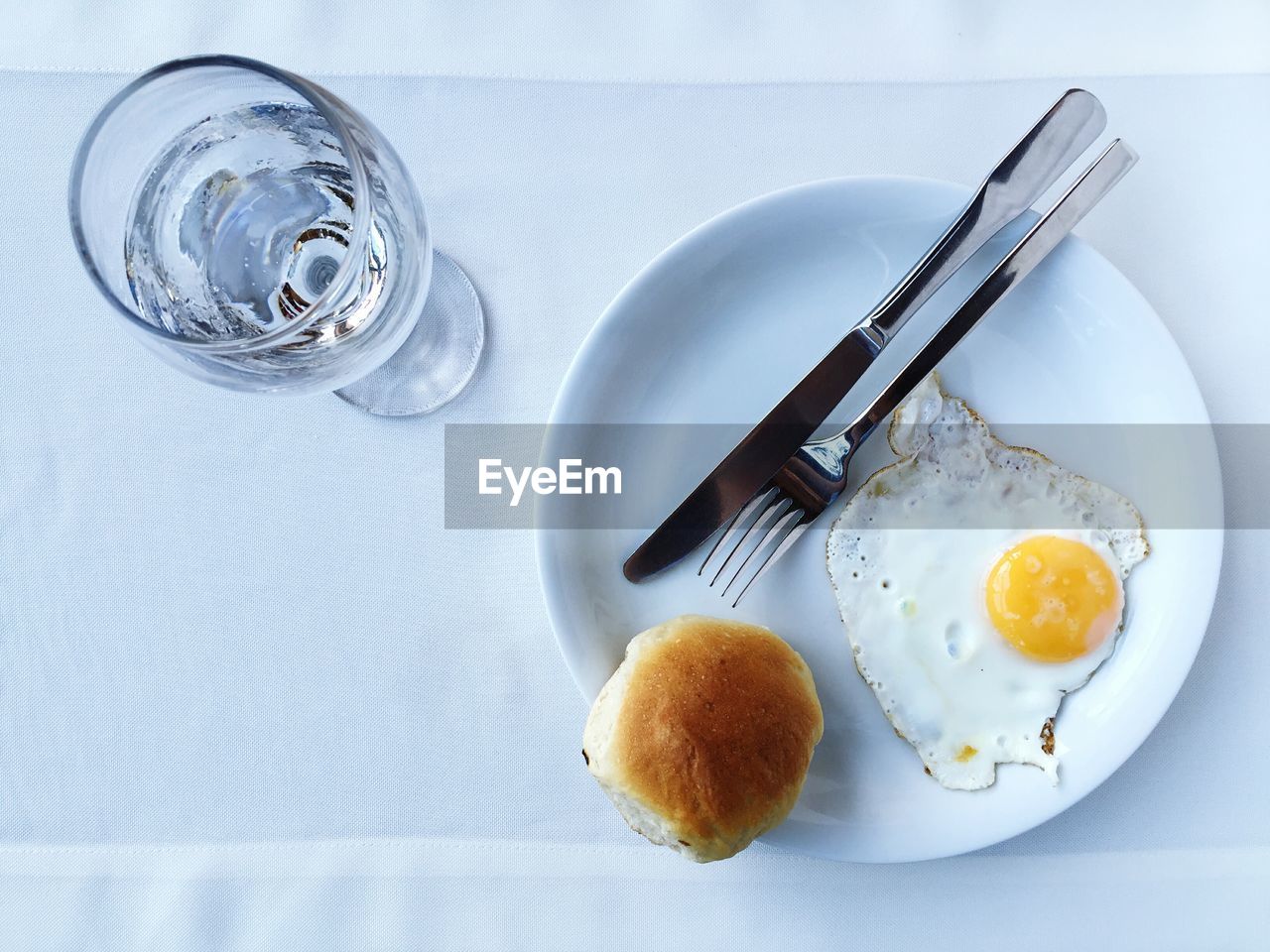 High angle view of fried egg in plate by glass on table