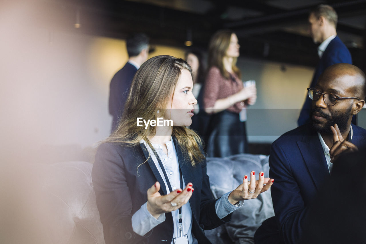 Female entrepreneur talking to male coworker at workplace