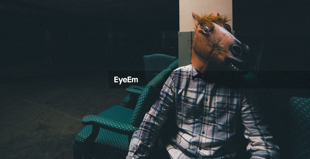 Man wearing mask sitting on seat