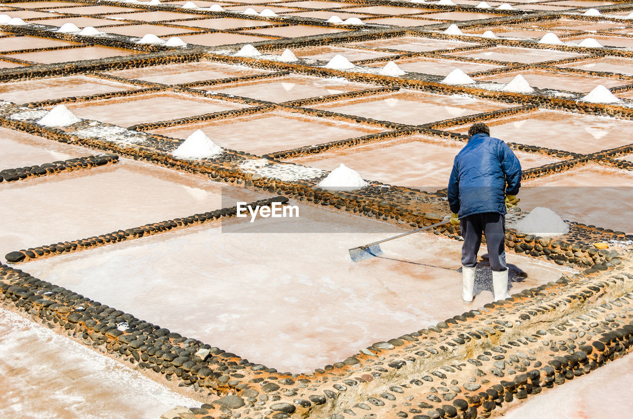 Rear view of workers working at salt flat