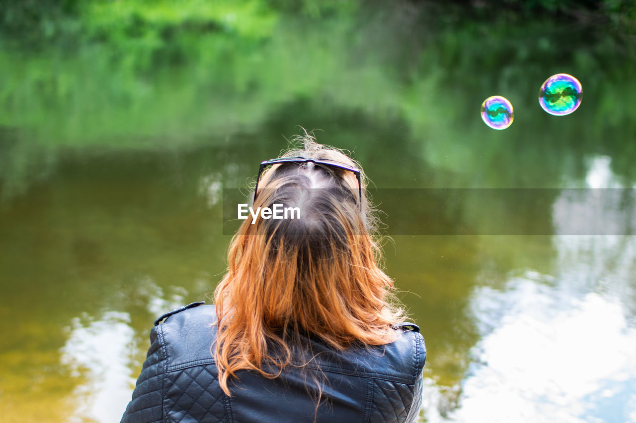 PORTRAIT OF WOMAN WITH BUBBLE IN LAKE