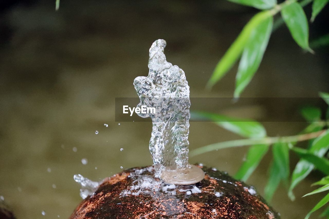 CLOSE-UP OF WATER SPLASHING ON ROCK