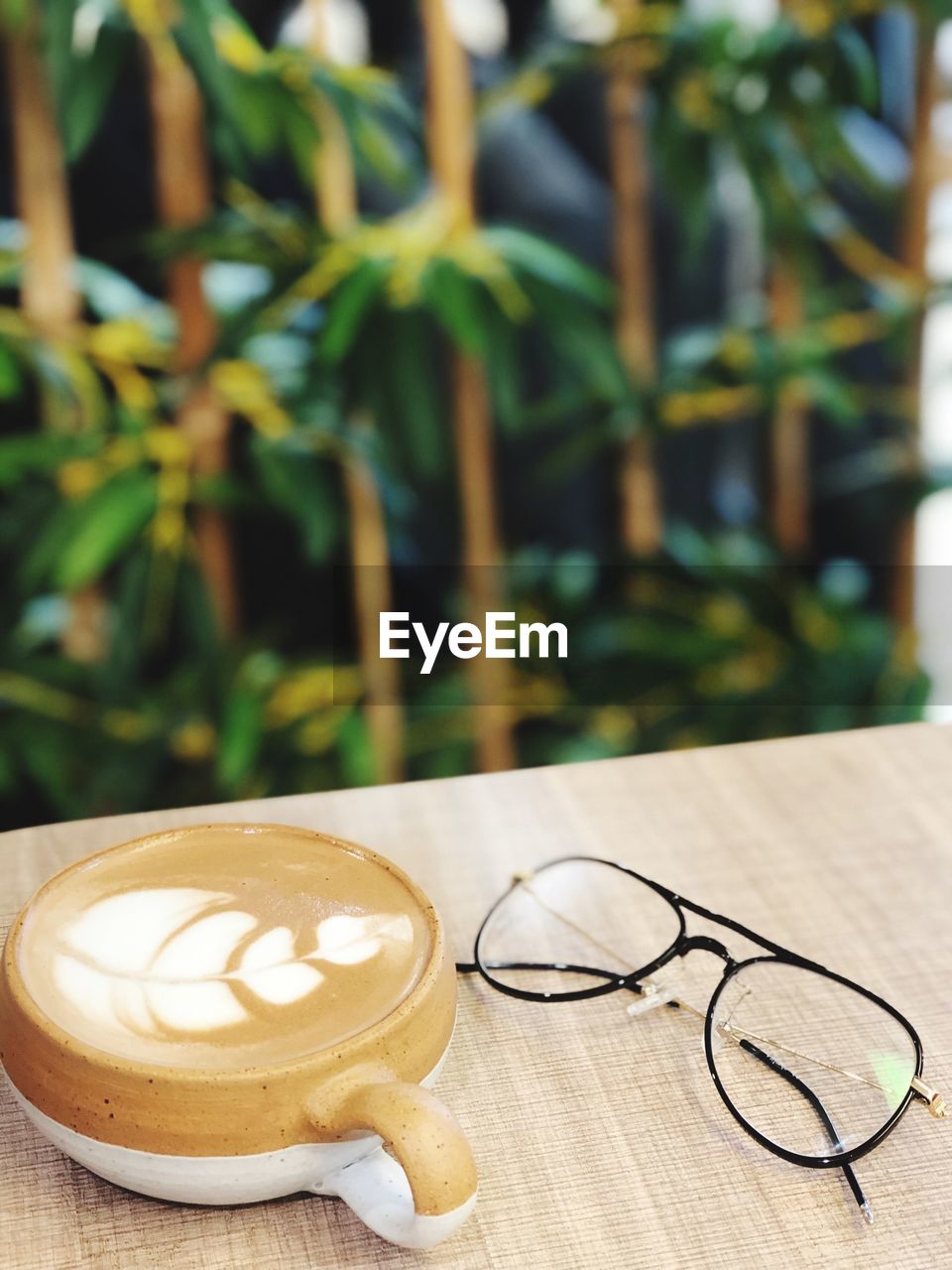 Close-up of coffee with eyeglasses on table