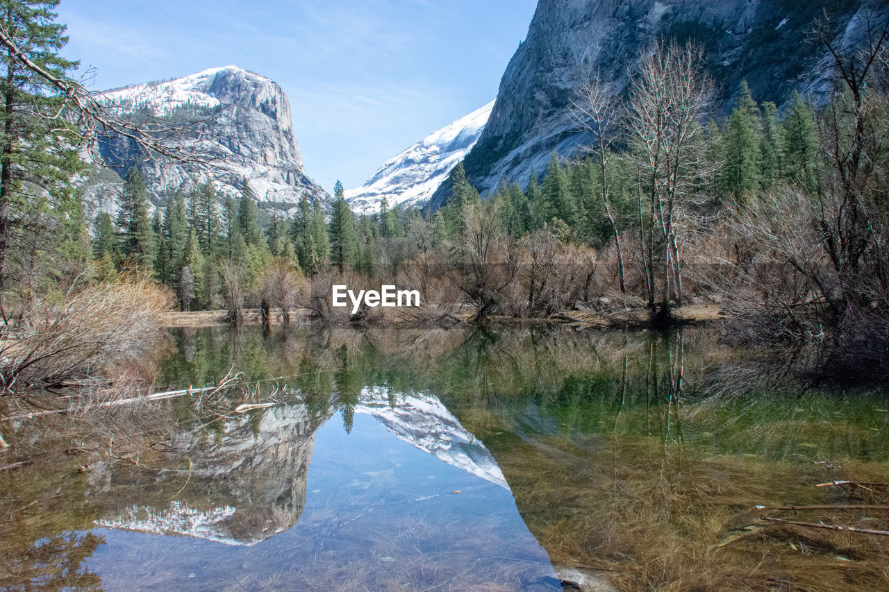 Scenic view of lake by mountains against sky