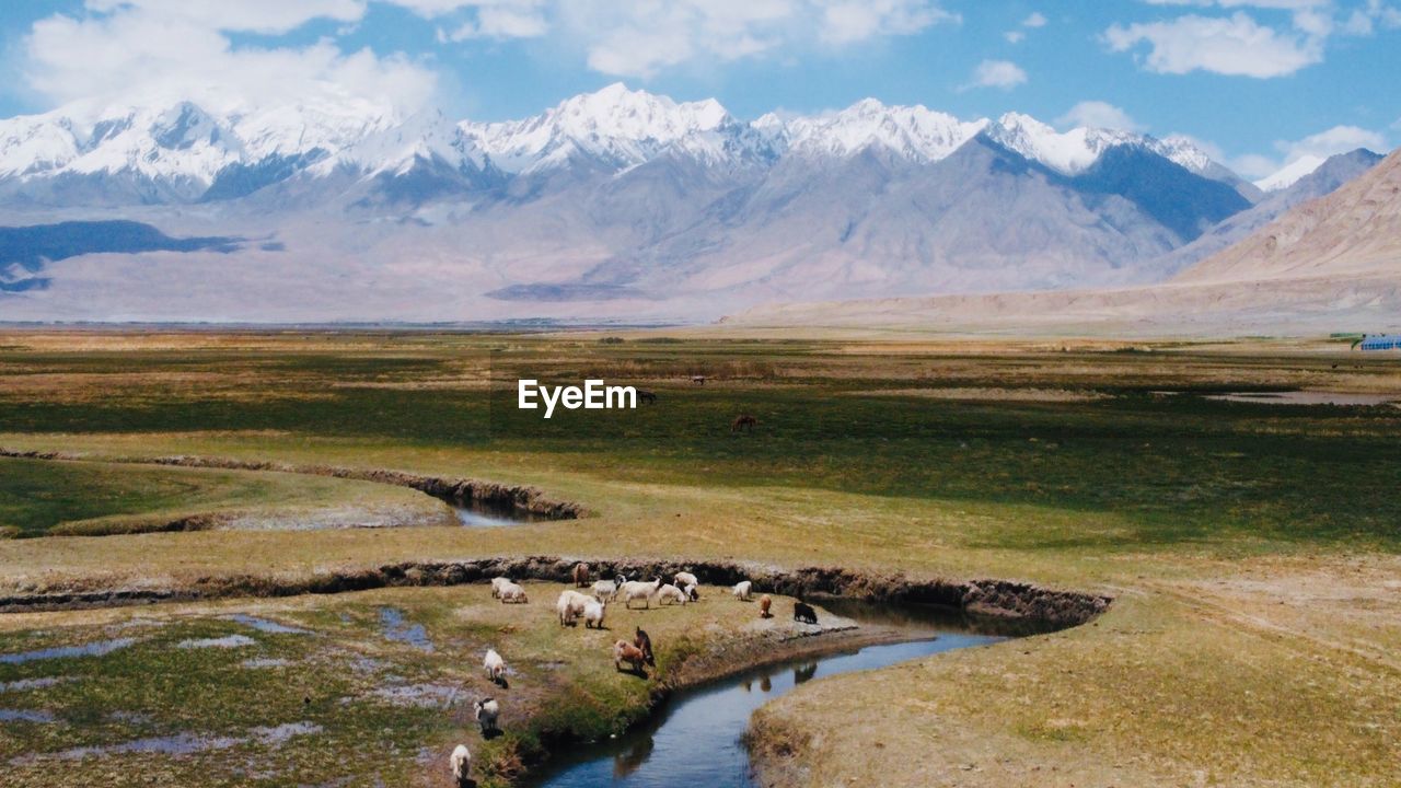 Scenic view of lake by mountains against sky