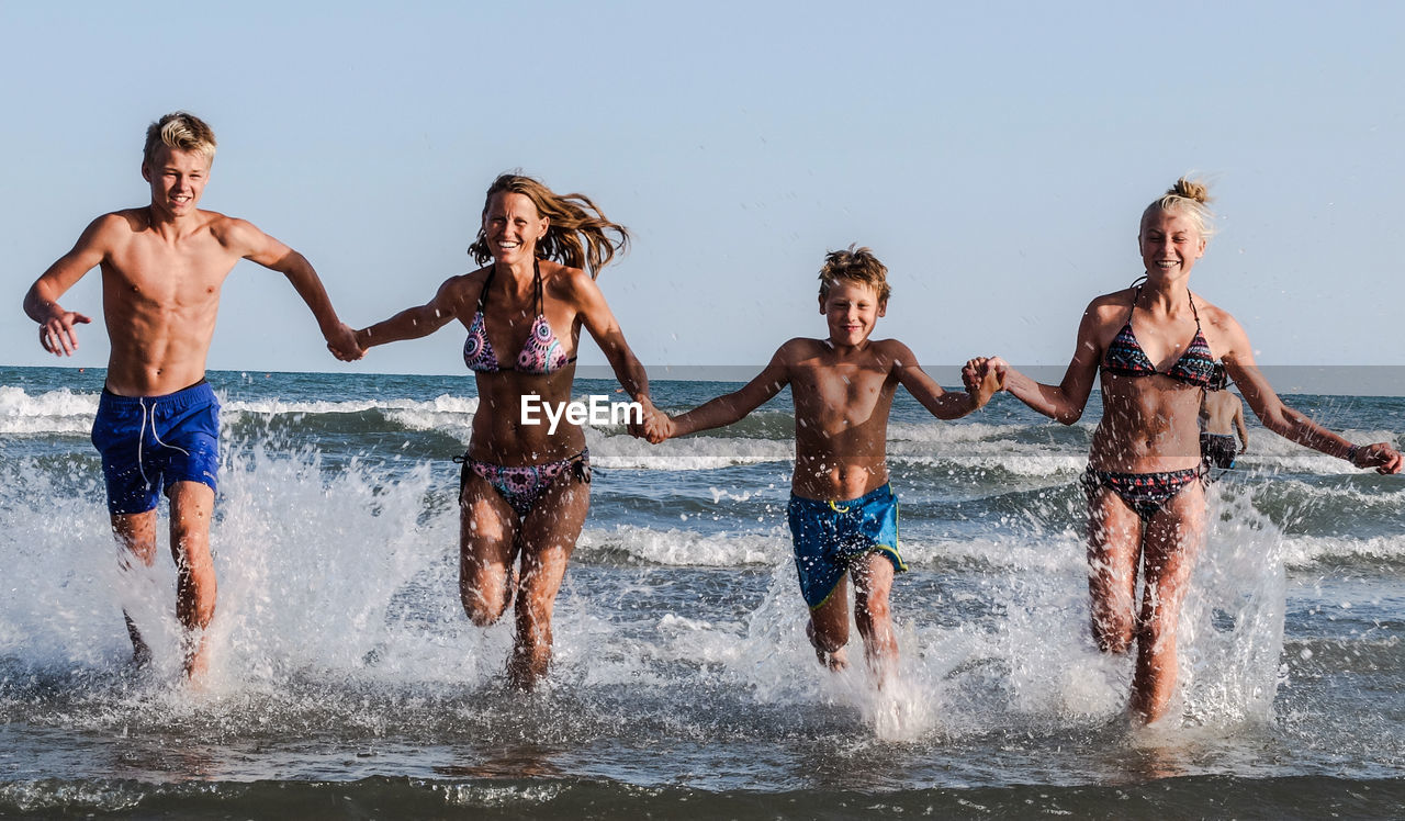 People enjoying in sea against sky