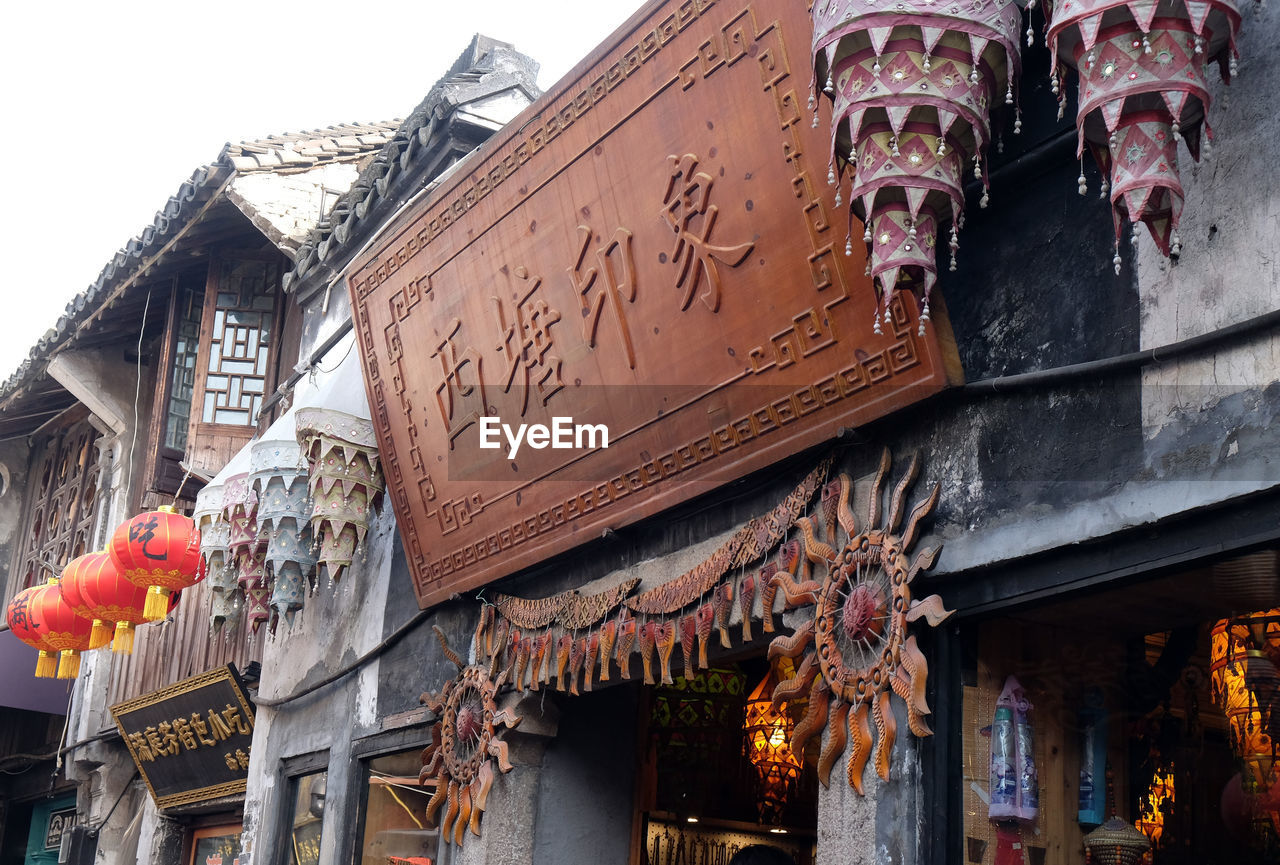 LOW ANGLE VIEW OF LANTERNS HANGING ON BUILDING