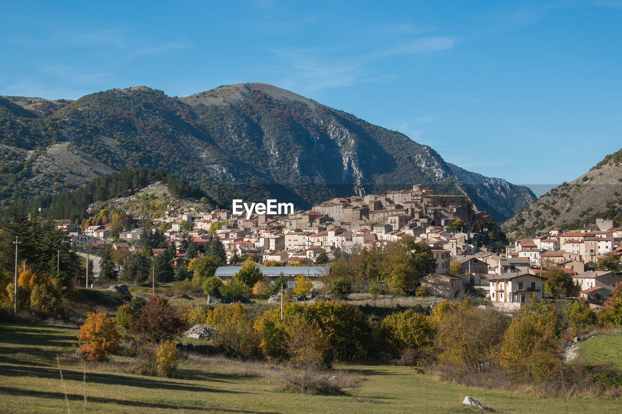 Townscape by mountains against sky