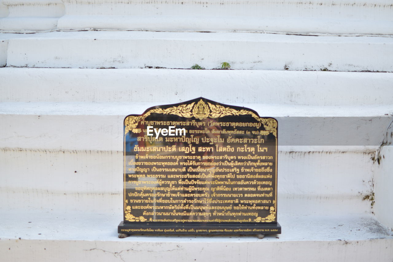 CLOSE-UP OF TEXT ON METAL WALL