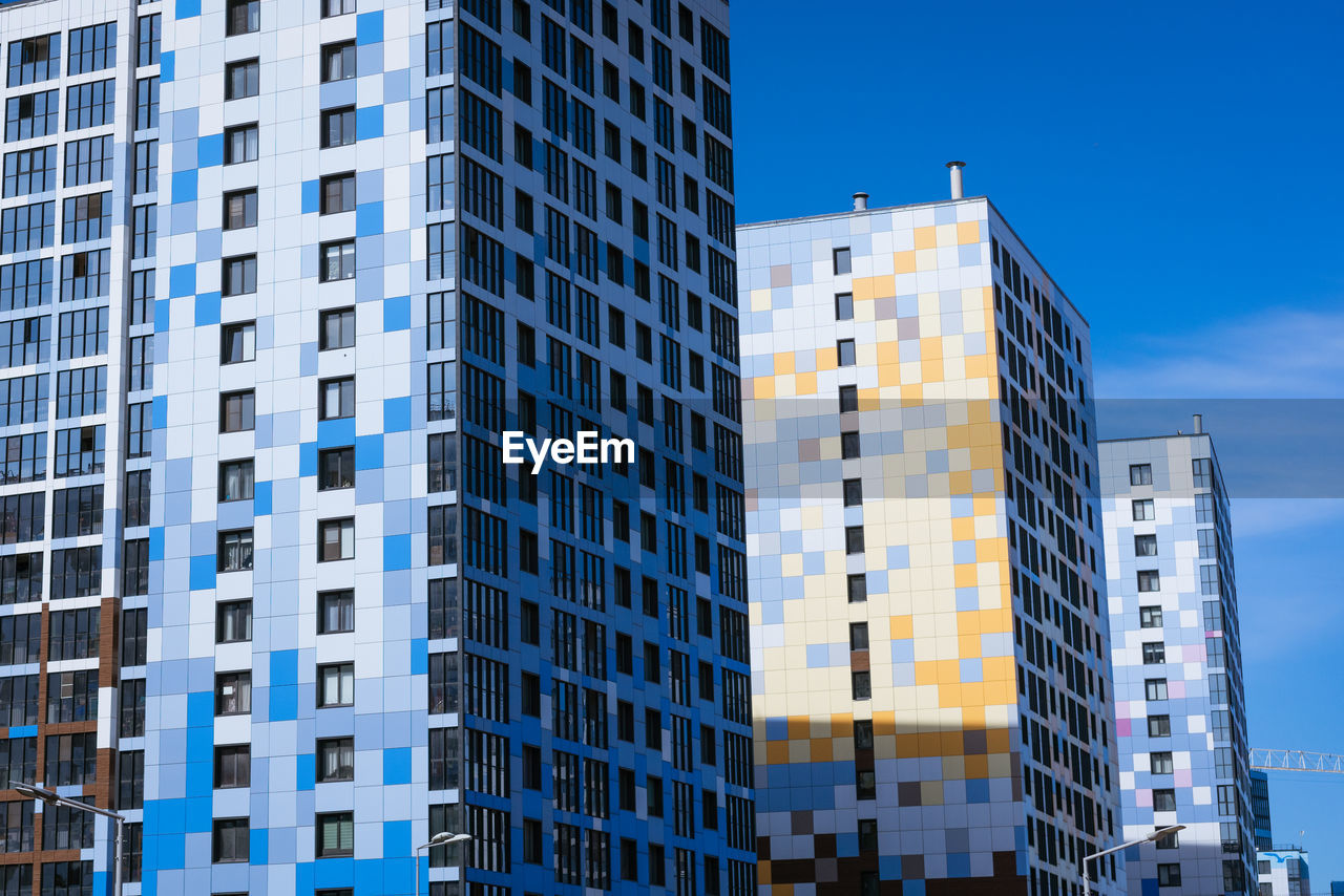 Facades of high-rise buildings against a blue sky