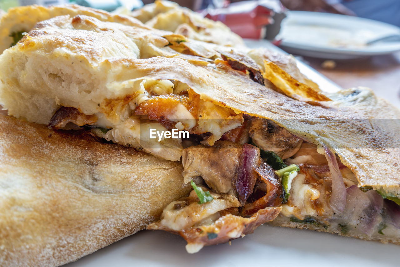 CLOSE-UP OF BREAD WITH MEAT AND SAUCE IN PLATE