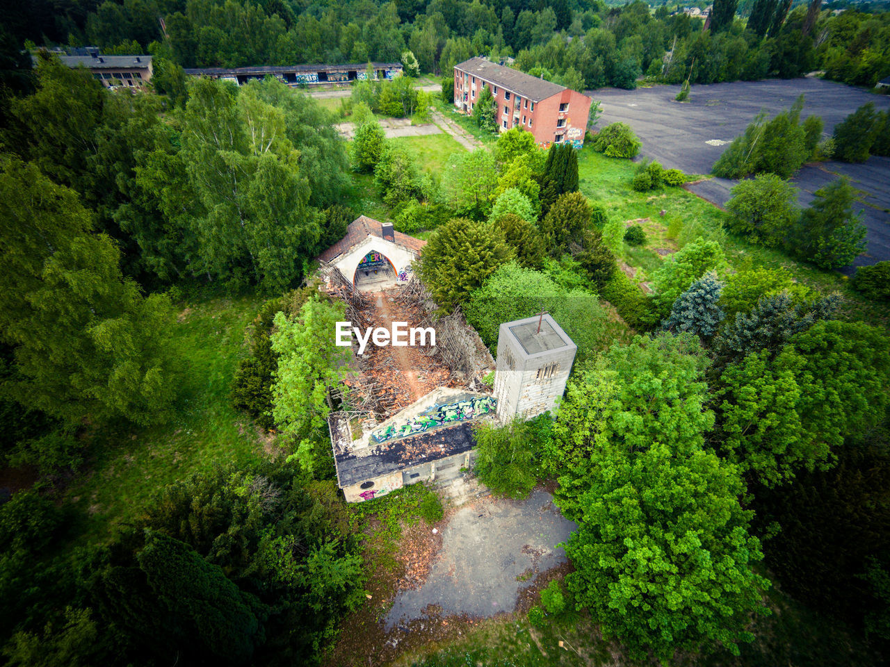 High angle view of abandoned house amidst trees on field