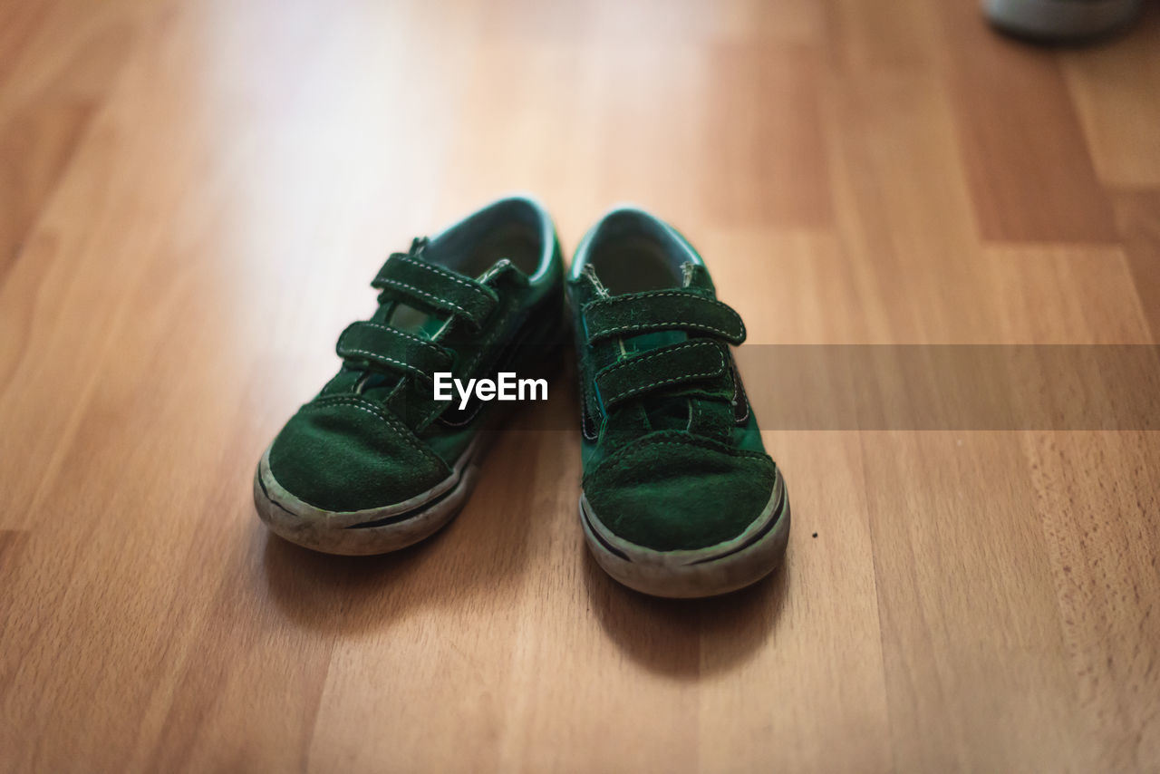 HIGH ANGLE VIEW OF SHOES ON WOODEN TABLE