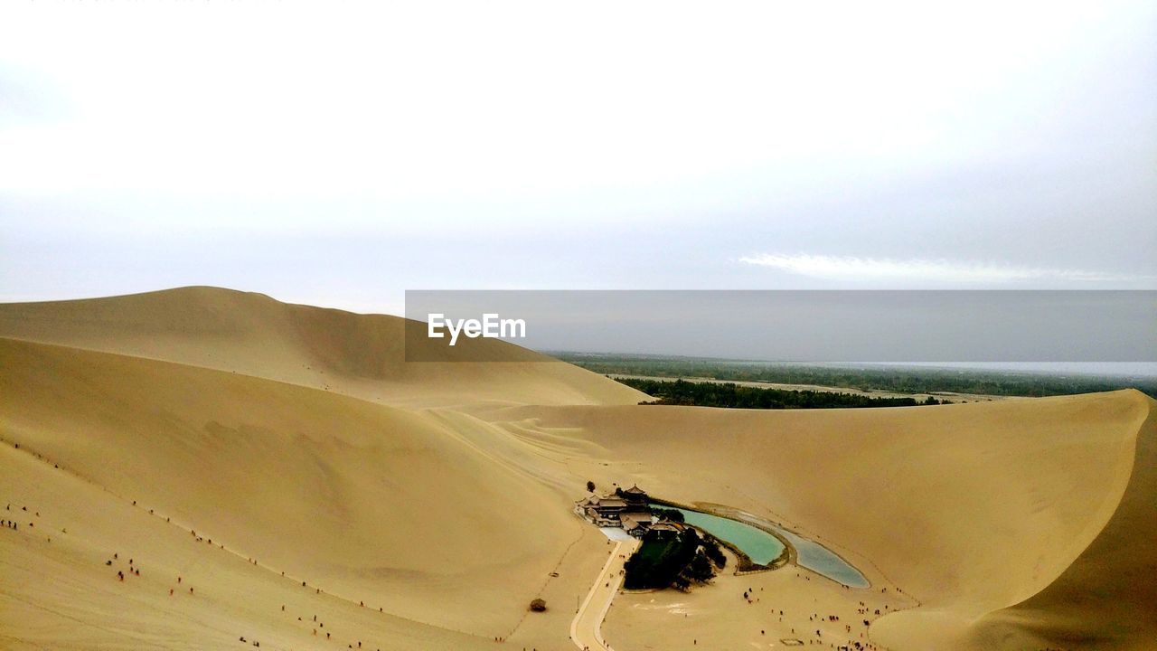 SCENIC VIEW OF SAND DUNES AGAINST SKY